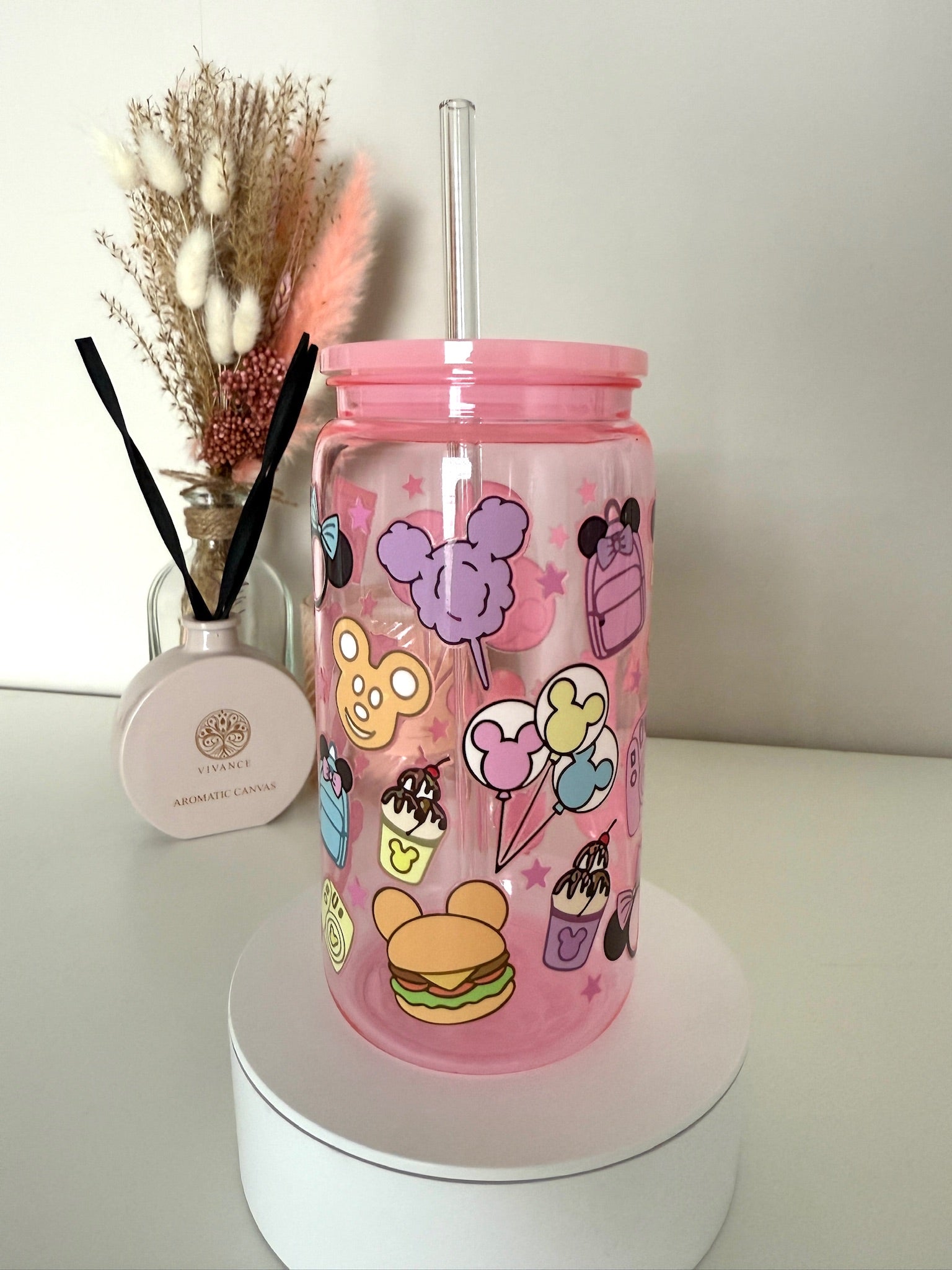 Roze drinkbeker met Disney-geïnspireerde illustraties van donuts, strikken, pizza, camera en pastel oortjes