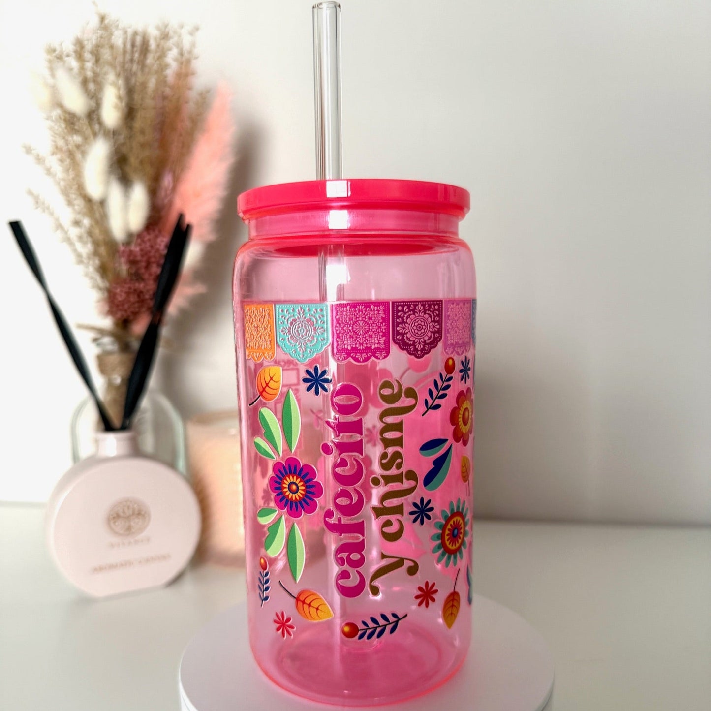 Felroze drinkbeker met de tekst “Cafecito & Chisme”, bloemen, rietje en kleurrijk Latijns design