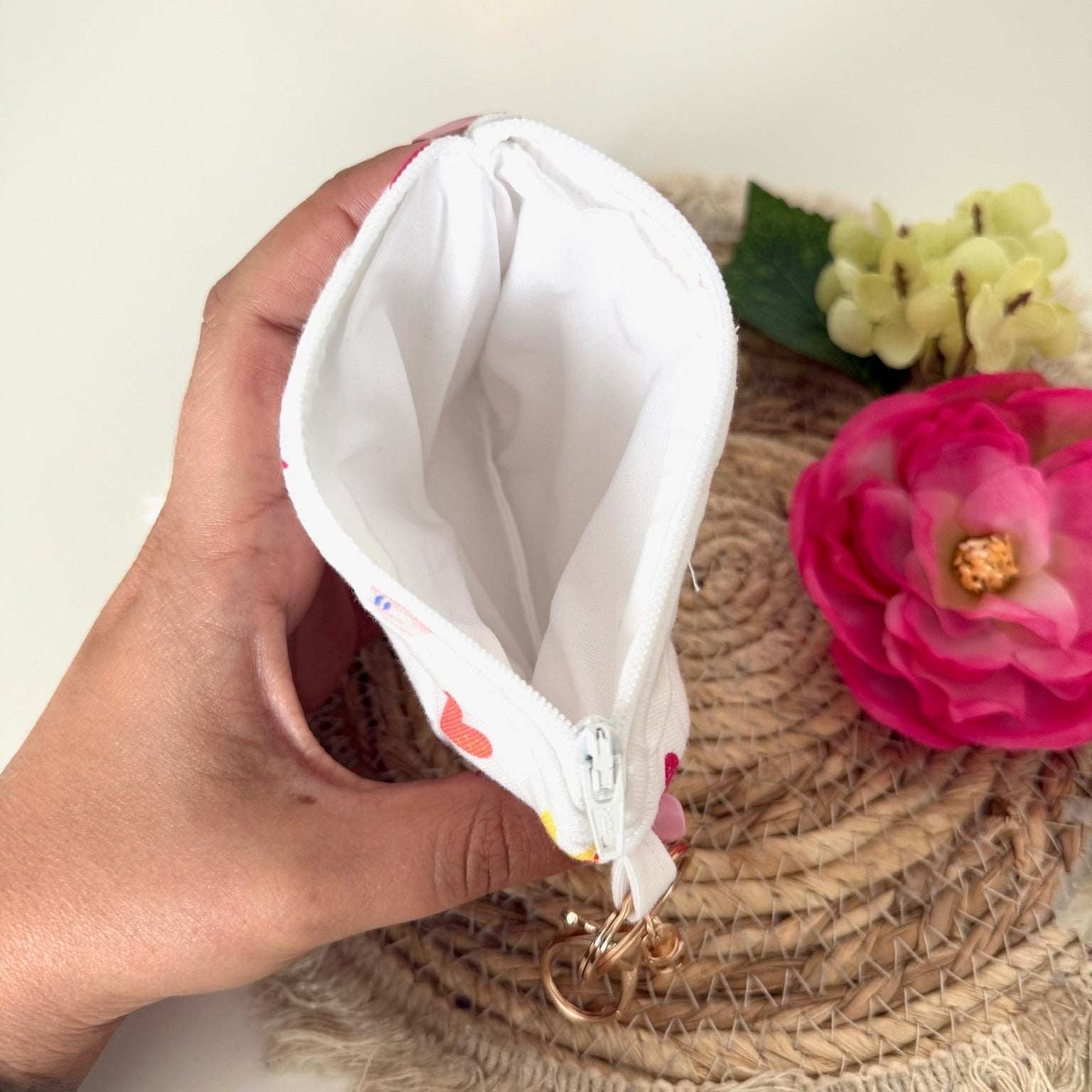 Gequilte witte mini portemonnee met kleurrijke hartjes en metalen clip, gevuld met pasjes en muntgeld