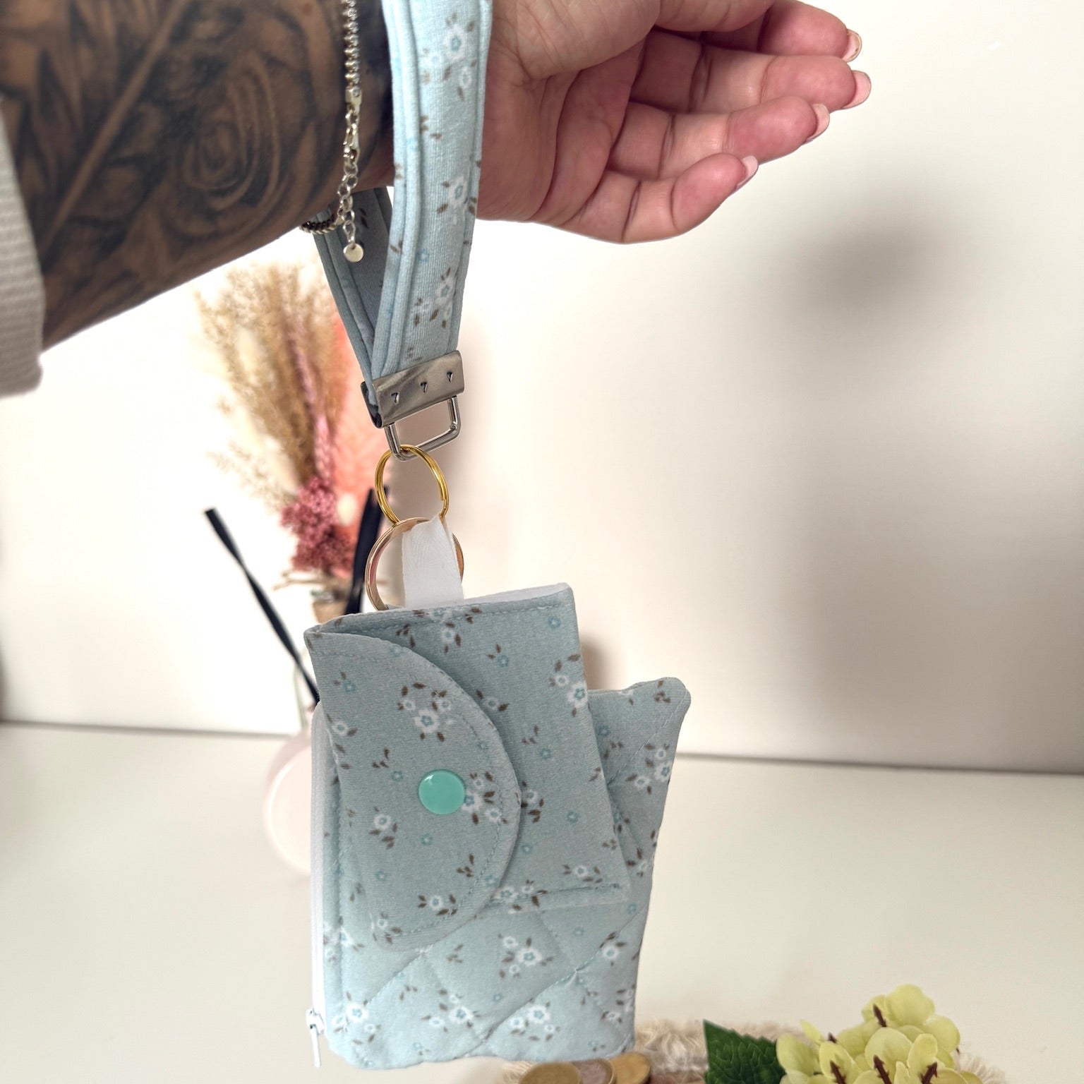 Gequilte Blauwe mini portemonnee met witte bloemetjes en metalen clip, gevuld met pasjes en muntgeld