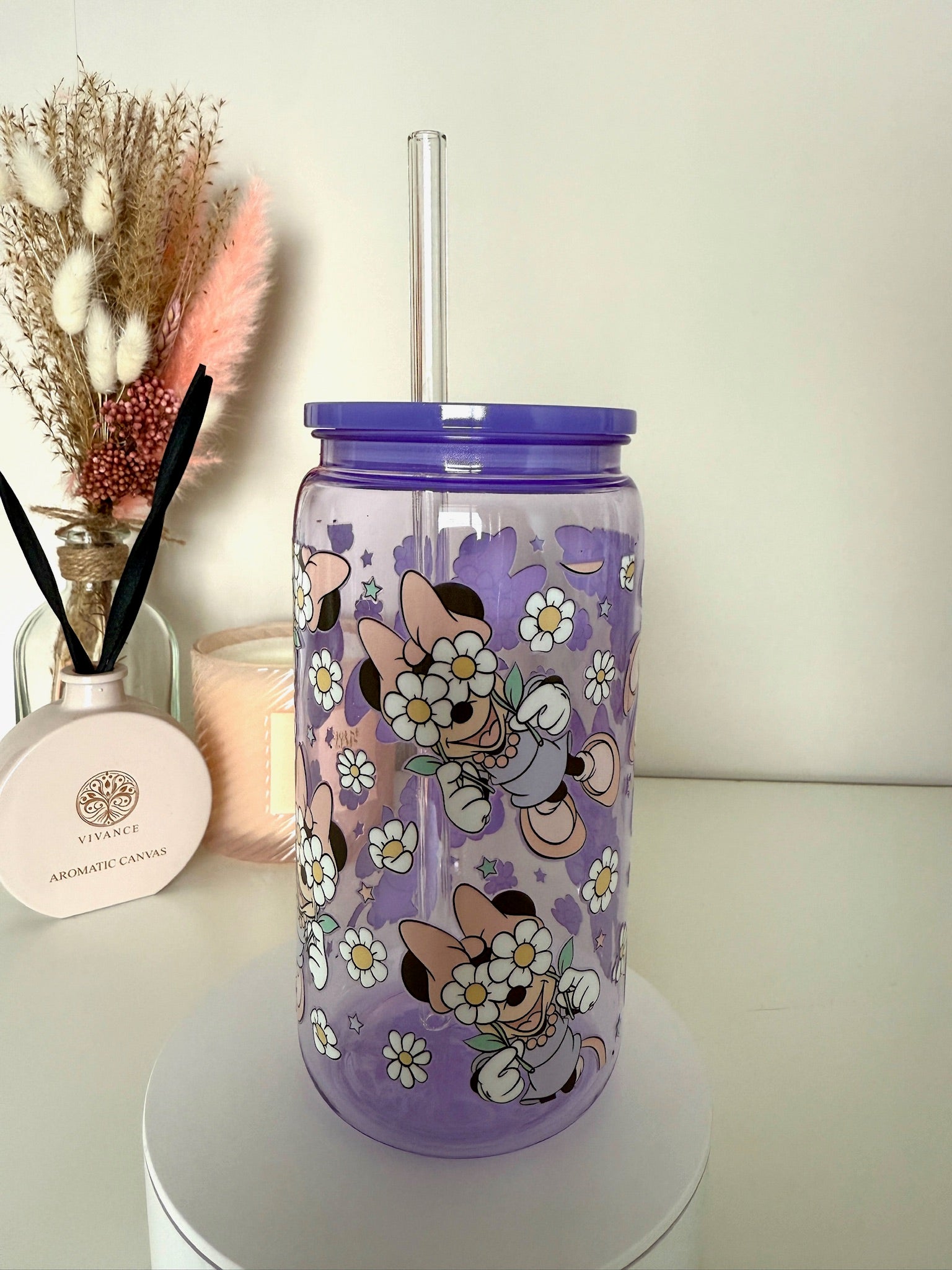 Lila drinkbeker met rietje en bloemenprint, cartoonfiguur in pastelkleuren