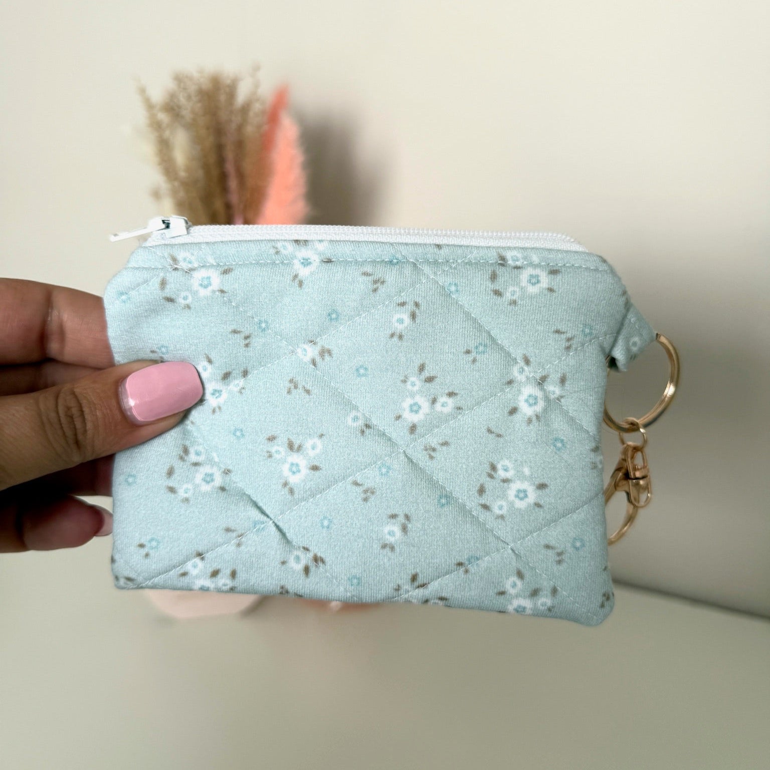 Gequilte Blauwe mini portemonnee met witte bloemetjes en metalen clip, gevuld met pasjes en muntgeld