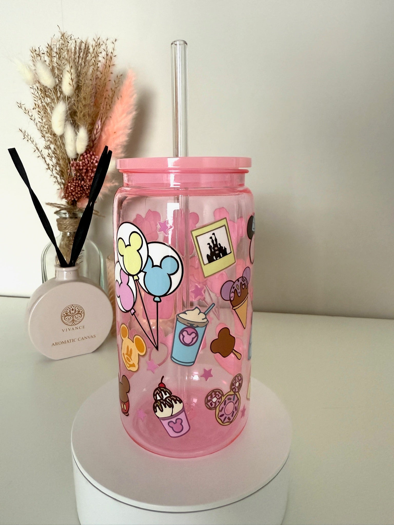 Roze drinkbeker met Disney-geïnspireerde illustraties van donuts, strikken, pizza, camera en pastel oortjes